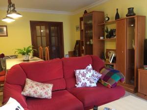 马拉加Como en casa的客厅里配有红色沙发,配有枕头