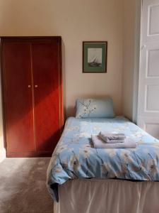 罗撒西Commodore Guesthouse, Self-Catering Suites的一间卧室,在衣柜旁配有一张床
