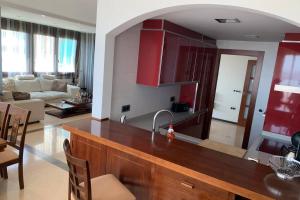多列毛利诺斯Maravilloso piso en Torremolinos, Costa del Sol的厨房以及带红色橱柜和桌子的客厅。