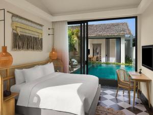 富国New World Phu Quoc Resort的一间卧室设有一张床和一个游泳池