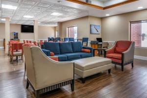 斯泰茨伯勒Comfort Inn & Suites Statesboro - University Area的一间配备有蓝色沙发和椅子的等候室