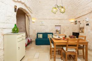 奥斯图尼Lovely Stone House In Ostuni的厨房以及带桌椅的用餐室。