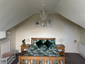 马特洛克Danbury Lodge Penthouse的一间卧室配有一张带绿色枕头的床