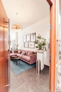 海德堡Fabelhafte Wohnungen in der Altstadt的客厅配有粉红色的沙发和桌子