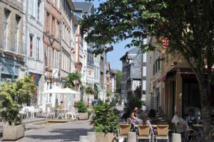 鲁昂Sous Les Nuages的一条城市街道,人们坐在椅子上