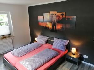温特贝格Apartment am Felsen Züschen的一间卧室设有两张床,墙上挂有绘画作品