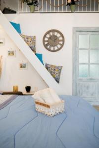 莫诺波利Home Bibi的一间设有蓝色床的客房,墙上挂着一个时钟