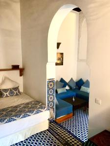 非斯达尔皮埃尔庭院旅馆的配有床和蓝色沙发的房间