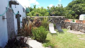Biscoitos桥下度假屋的一个带两把椅子和石墙的花园