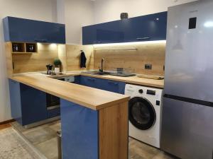 班斯科Monteverde Ski Lift Apartment Bansko的厨房配有蓝色橱柜和洗衣机。