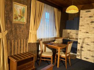 Zlatníky奥鲁姆旅馆的厨房配有桌椅和窗户。