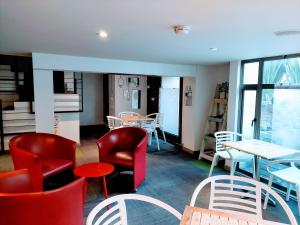 波哥大Hotel Viaggio Teleport City Suites的餐厅设有红色和白色的椅子和桌子