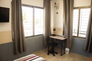 切图马尔Departamento Orellana 11的一间卧室配有书桌、两个窗户和一张床