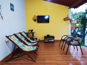 卡罗莱纳Pousada Águas da Chapada的客厅配有椅子和黄色墙壁上的电视