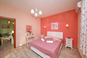 尼欧克利马Koromilia Villa的一间红色墙壁的卧室和一张粉红色床单