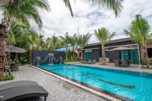 班武里府Coco Pina的棕榈树屋前的游泳池