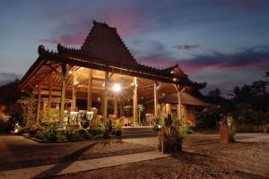 婆罗浮屠Bhumi Kasuryan Borobudur的大型木制凉亭,晚上有屋顶