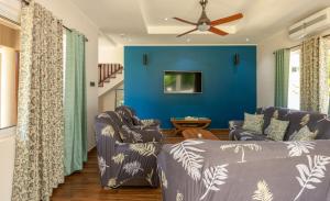 拉迪格岛The Garden Villas - La Digue的客厅设有两张沙发和一堵蓝色的墙壁