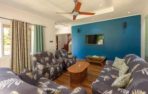拉迪格岛The Garden Villas - La Digue的客厅设有蓝色的墙壁和沙发。