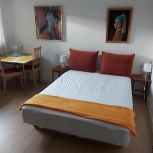 SpangGuesthouse Sønderborg, Ulkebøl的一间卧室配有一张床和一张桌子及一张桌子