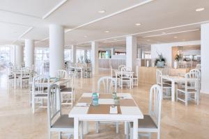 波多·纳奥斯索尔拉帕尔玛酒店的一间设有白色桌子和白色椅子的餐厅