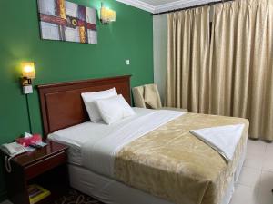 迪拜皇家王子酒店的一间卧室设有一张床和绿色的墙壁