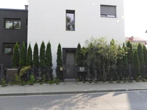 克拉科夫Apartament A2D Kraków的白色的房子,有黑色的大门和树木
