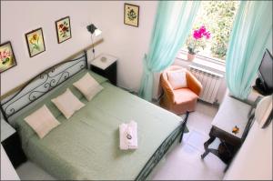 伊斯基亚Hotel Casa Nicola的卧室配有床、椅子和窗户。