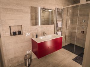 梅拉诺Sweet Piccolo Loft in centro con incantevole idromassaggio的一间带红色水槽和淋浴的浴室
