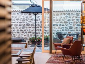 梅拉诺Sweet Piccolo Loft in centro con incantevole idromassaggio的庭院配有桌椅和遮阳伞。