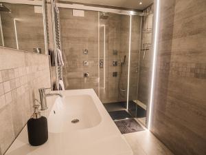 梅拉诺Sweet Piccolo Loft in centro con incantevole idromassaggio的带淋浴和白色盥洗盆的浴室
