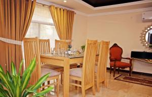 拉合尔Luxury 3 Bedrooms Apartment的一间带木桌和椅子的用餐室
