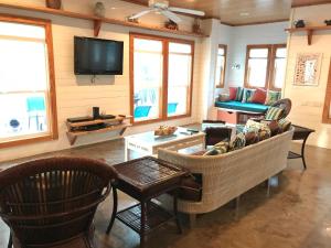 阿兰瑟斯港Coral Paradise 27VW的客厅配有沙发、椅子和电视