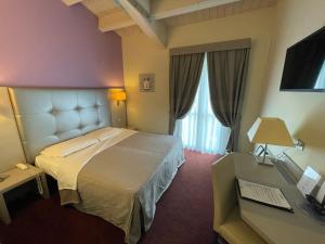 雷诺河畔卡萨莱基奥卡尔扎维切诺精品酒店的配有一张床和一张书桌的酒店客房