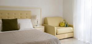 里乔内斯梅拉尔多套房酒店的一间卧室配有一张床和一张黄色椅子