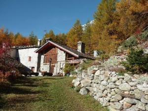 库马约尔Chalet Berlot的一座房子,建筑旁边设有石墙