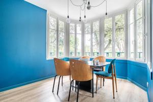 诺亚芒提亚Charmante maison pour 5 personnes sur l'Ile de Noirmoutier的一间拥有蓝色墙壁和桌椅的用餐室