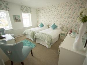 梅瑟蒂德菲尔女王蜜蜂&B旅馆的一间卧室配有两张床、一张桌子和一把椅子