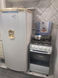 马蒂尼奥斯Casa 50 mts da praia Caravelas PR com ventiladores的一间带冰箱和炉灶的小厨房