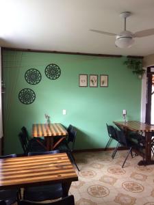 弗洛里亚诺波利斯POUSADA LOS AMIGOS CAMPECHE的一间设有两张桌子的房间和绿色的墙壁