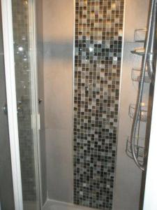 伦敦Kew Gardens National Archives Forest Road的浴室设有马赛克瓷砖和墙壁上的淋浴。