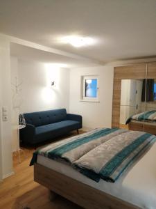 施坦察赫Sand 4的一间卧室配有一张大床和一张蓝色的沙发