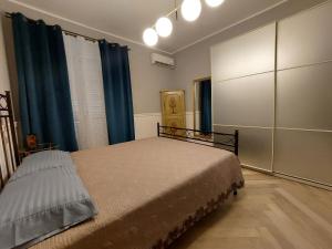 都灵Casa Madama Rossini的一间卧室配有床和蓝色窗帘