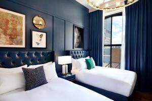 路易斯威尔The Grady Hotel的蓝色墙壁客房的两张床