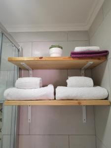 法鲁Tiny House Faro的浴室内带毛巾的木制架子