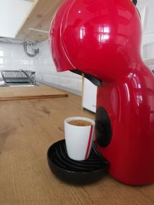 法鲁Tiny House Faro的咖啡壶把咖啡倒进桌子上的杯子里