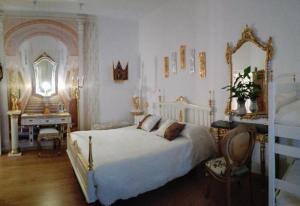 贝雅Império Romano Guest House的一间卧室配有一张床、一张书桌和一面镜子
