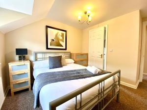艾尔斯伯里Aylesbury Contractor & Staycation Home的一间卧室配有两张床和吊灯。