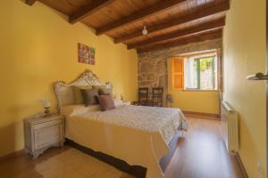 庞特维德拉A Casa da Charca - Casa rural con jardín的卧室配有一张床铺,位于一个黄色墙壁的房间