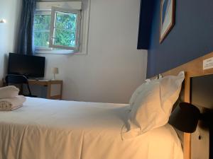 波城Hôtel Montilleul - Villa Primrose的一间卧室配有一张带白色床单的床和一扇窗户。